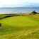 A putting green on a golf course overlooking a large body of water